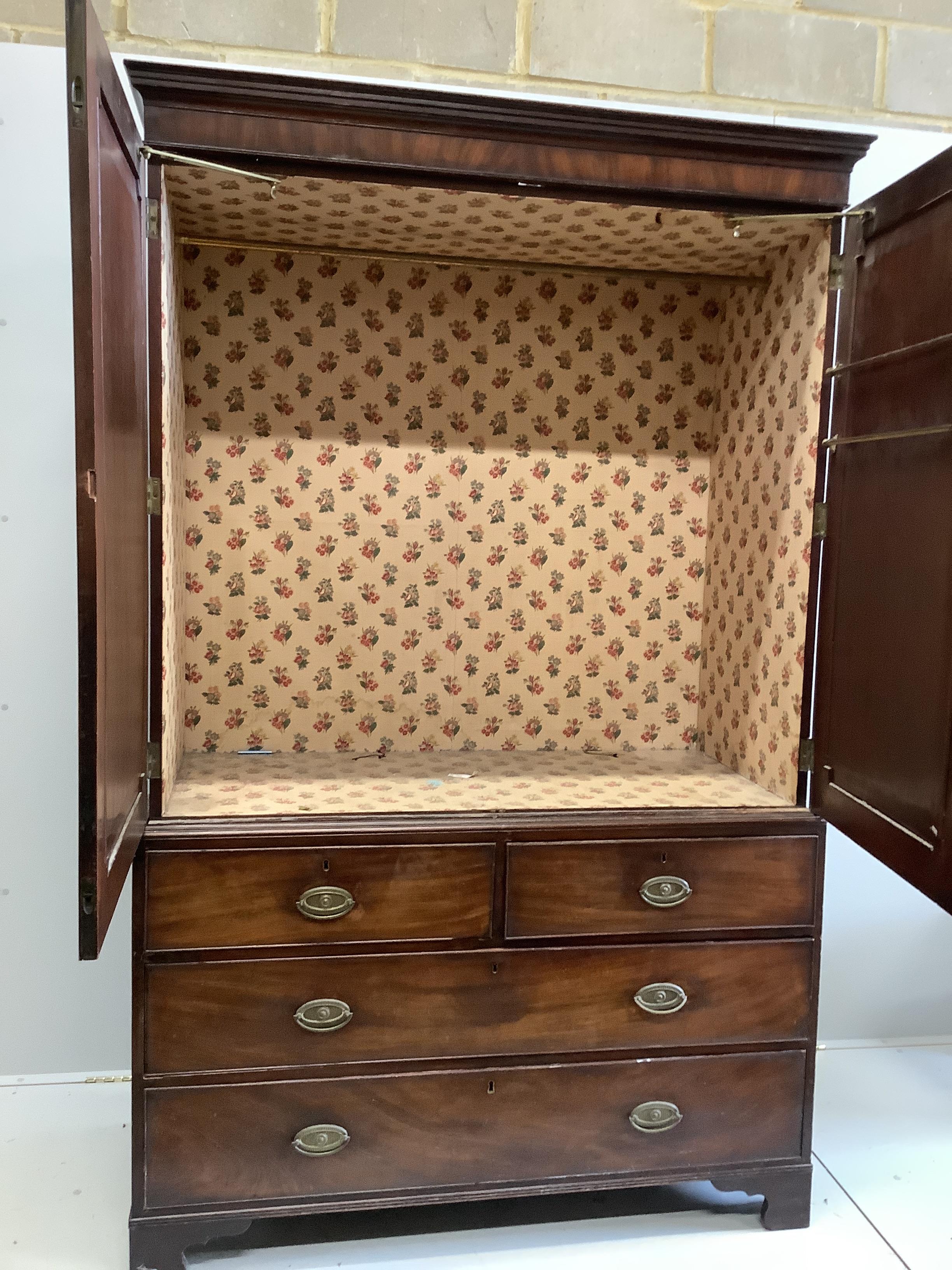 A George III mahogany linen press, converted to a hanging wardrobe, width 129cm, depth 58cm, height 206cm